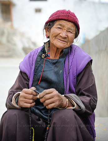 Old woman counting the beads on chain