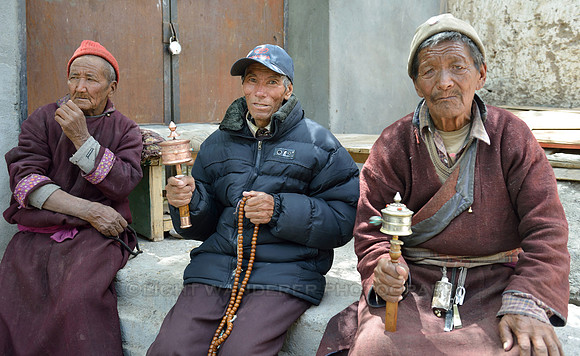 Old men spinning prayer wheels