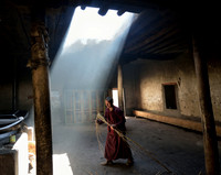 Monk bringing twigs to the fire