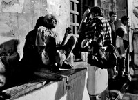 Beggar man talking with other