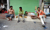 Young men taking rest after street cricket