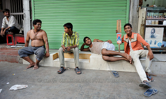 Young men taking rest after street cricket