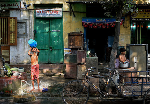 Man washing in the side of the street