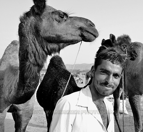 Man smiling, looking at the camera, holding his camel