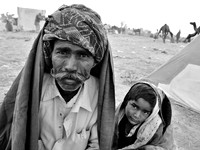 Man wearing a turban and large mouctache with a young boy