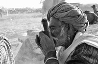 Man wearing a turban and golden earring smoking hashish,