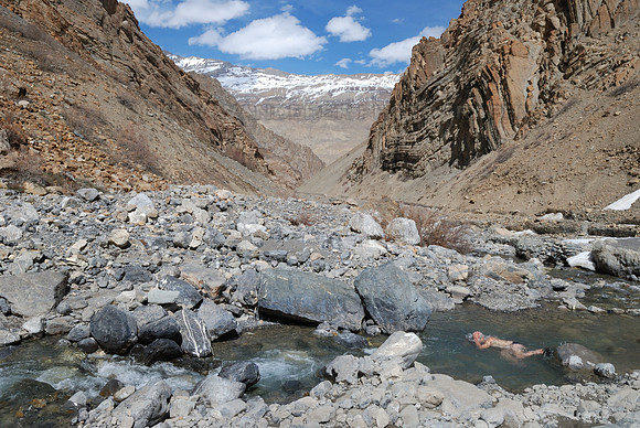 Hiker taking a dip in mountain stream