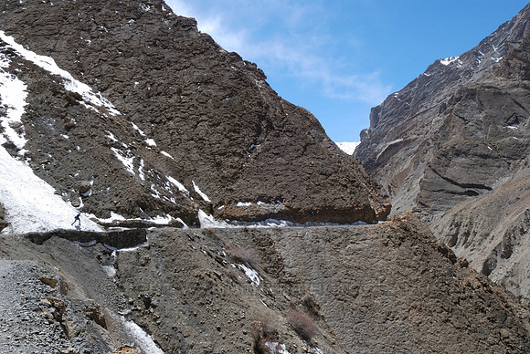 Hiker crossing quickly unstable batch of snow