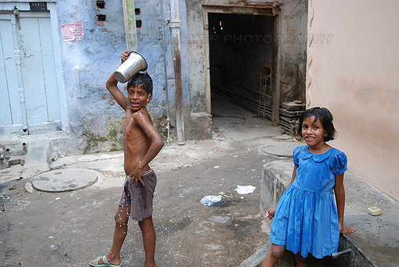 Boy having a wash in a courtyard