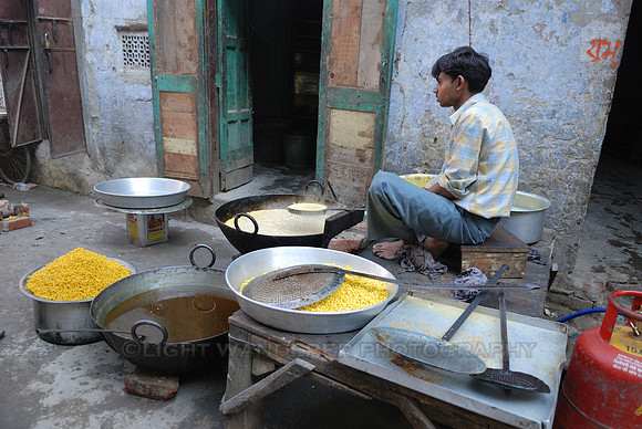 Young man boiling traditional sweets