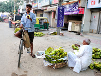 Man with bicycle eating banana