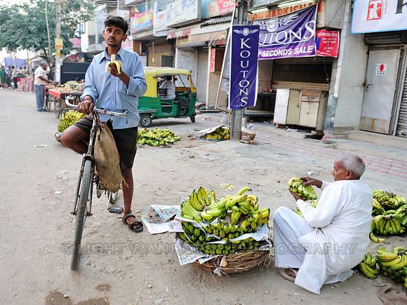 Man with bicycle eating banana