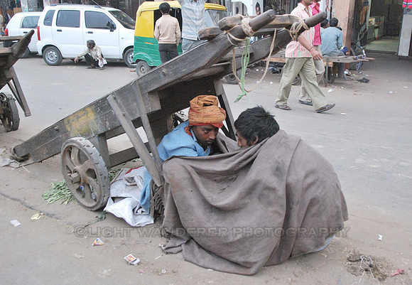 Two homeless young man crouching in the street