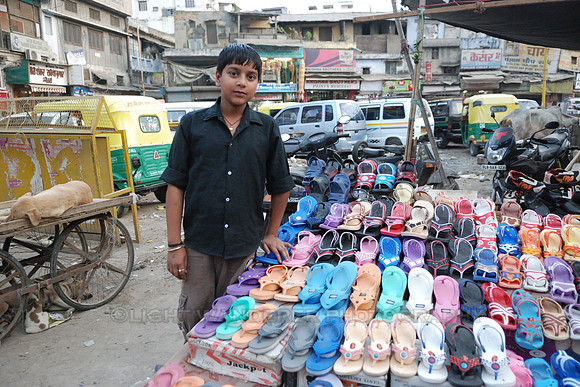 Young boy watching over older brother shoe selling stand