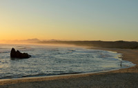 Man fishing on the beach at sunset time