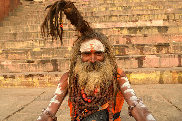 Smiling sadhu with dreadlocks pointing up